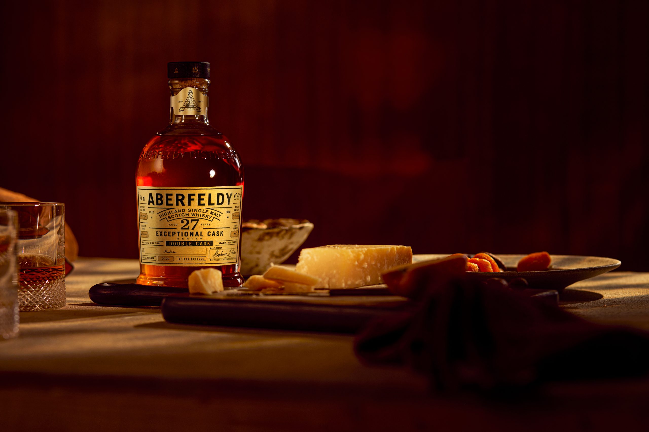 Aberfeldy 27 Year Old Madeira Double Cask bottle beside aged hard cheese and dried apricots