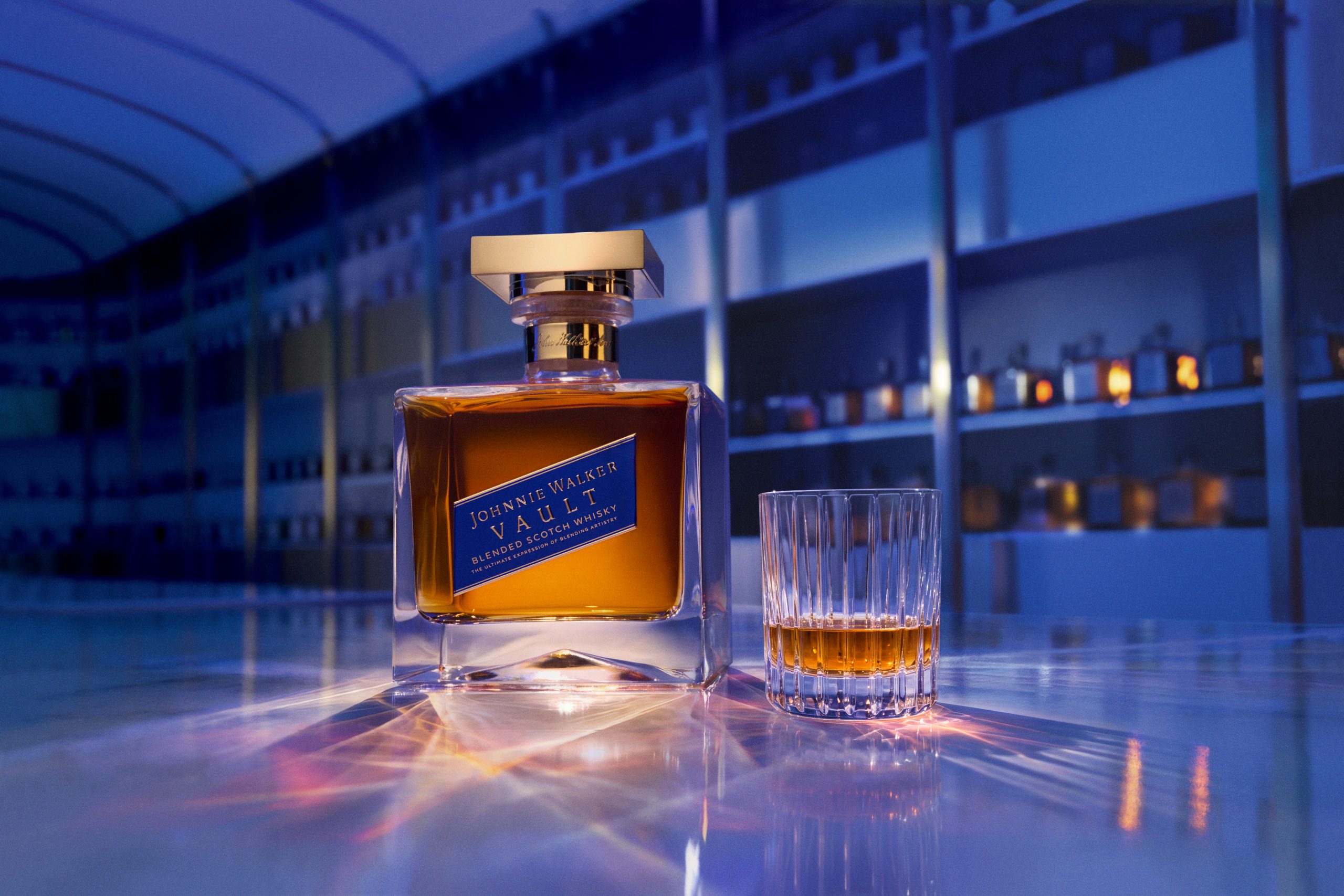 Johnnie Walker Vault 70cl bottle with gold square stopper beside a crystal tumbler of whisky, blended Scotch launched 2026